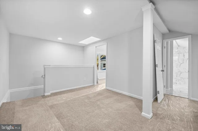 an empty room with windows and ceiling fan