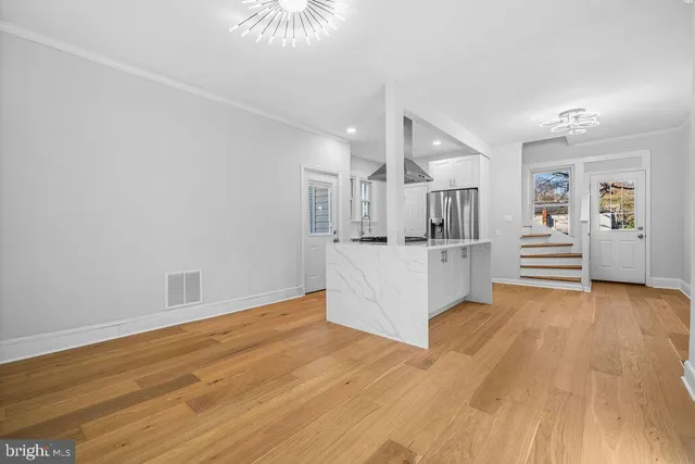 a view of a kitchen with wooden floor and electronic appliances
