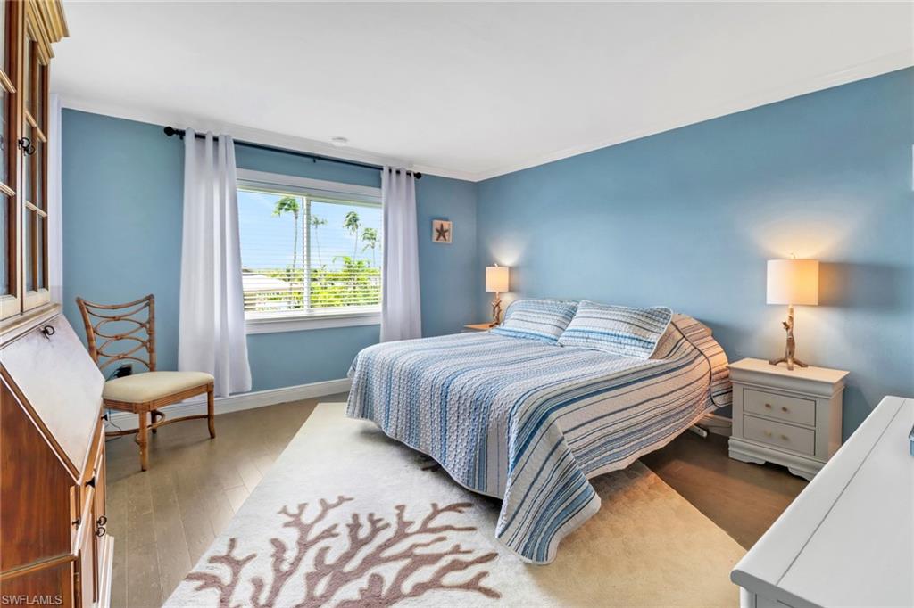 305 Goodlette Road South, Unit C302 Naples, FL 34102 - Photo 11 of 22 a bedroom with a bed and wooden floor