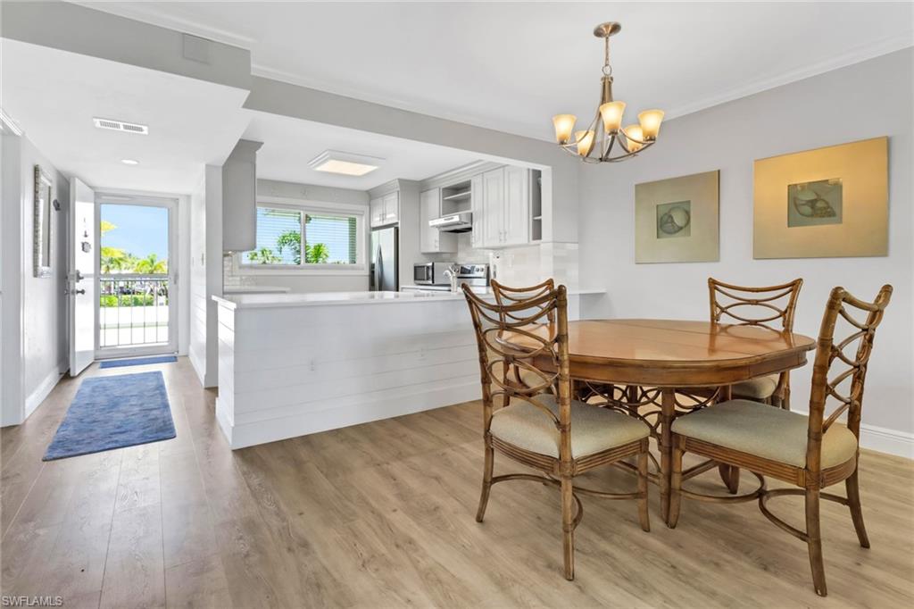 305 Goodlette Road South, Unit C302 Naples, FL 34102 - Photo 7 of 22 a view of a dining room with furniture and chandelier