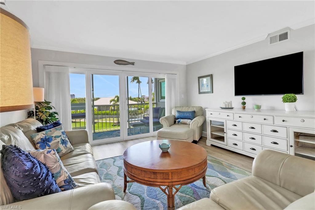 305 Goodlette Road South, Unit C302 Naples, FL 34102 - Photo 8 of 22 a living room with furniture and a flat screen tv