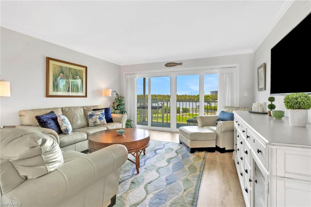 305 Goodlette Road South, Unit C302 Naples, FL 34102 - Photo 10 of 22 a living room with furniture large windows and flat screen tv