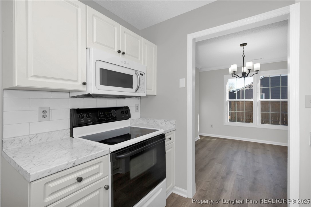 501 Camden Road Raeford, NC 28376 - Photo 17 of 35 a kitchen with granite countertop white cabinets and stainless steel appliances