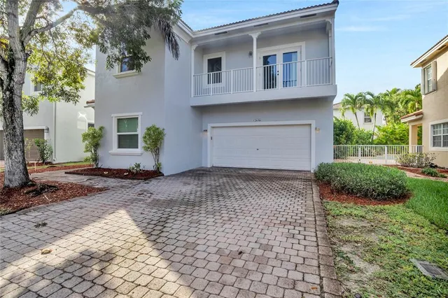 a front view of a house with a yard and potted plants