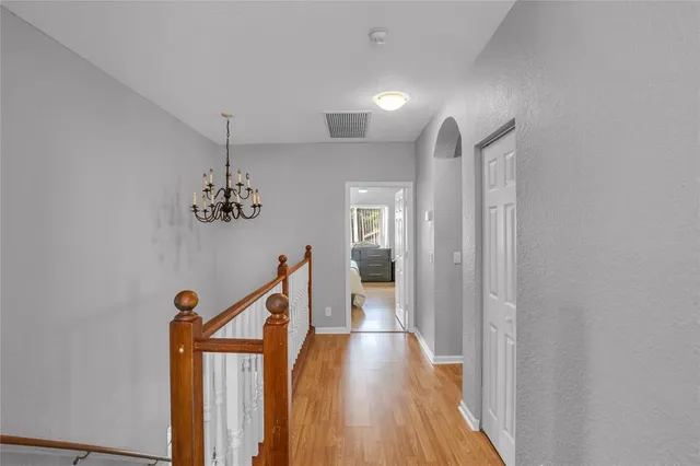 a view of a hallway with wooden floor and staircase