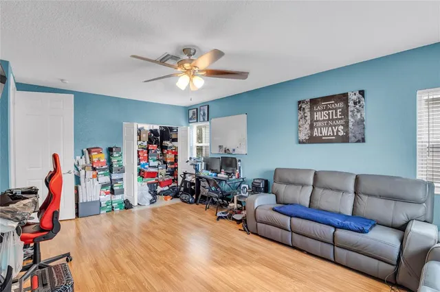 a living room with furniture a ceiling fan and a window
