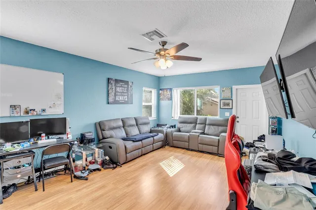 a living room with furniture a flat screen tv and a window