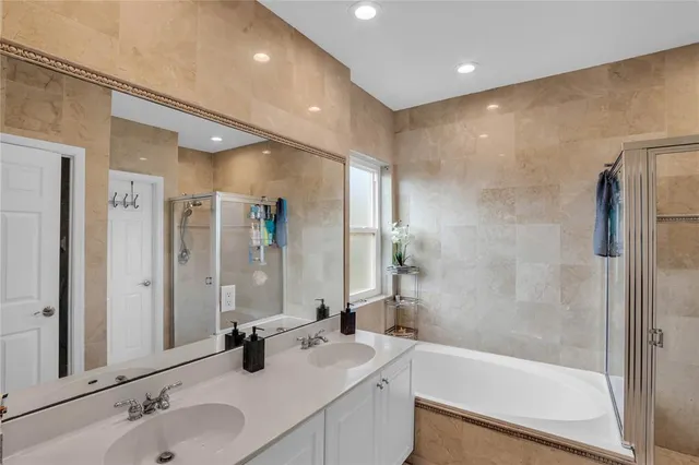 a bathroom with a tub shower sink and mirror
