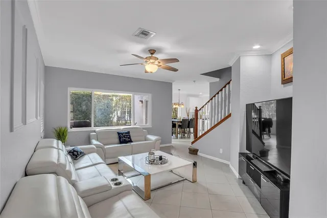 a living room with furniture ceiling fan and a window