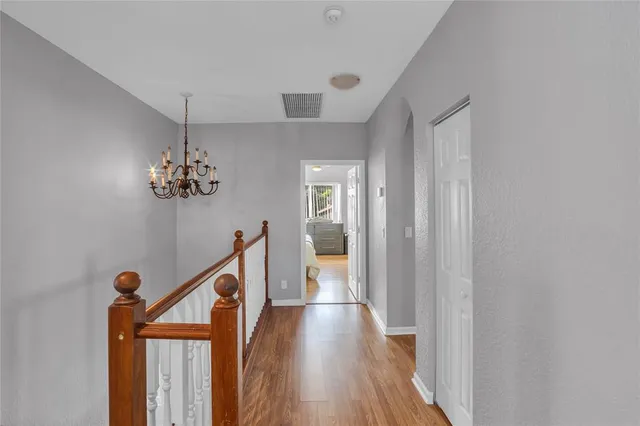 a view of a hallway with wooden floor and staircase