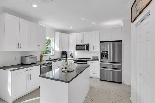 a kitchen with white cabinets and appliances