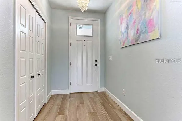 a view of a hallway with wooden floor and entryway
