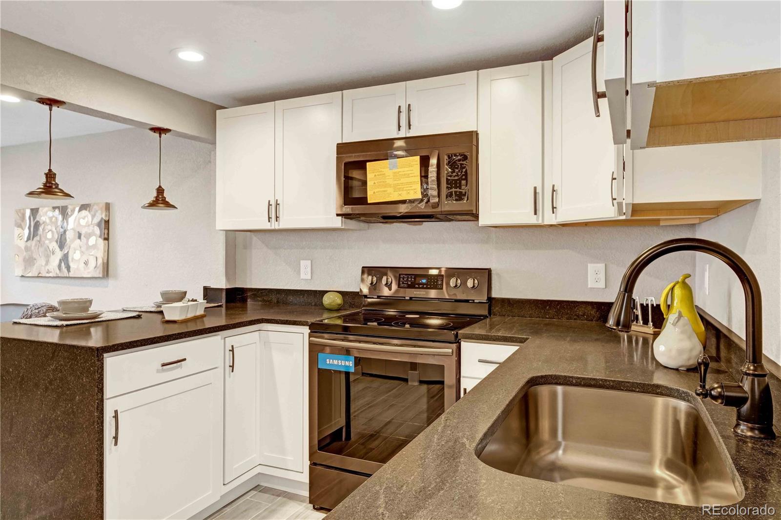 154 South Stuart Street Denver, CO 80219 - Photo 14 of 26 a kitchen with granite countertop a sink a stove and cabinets