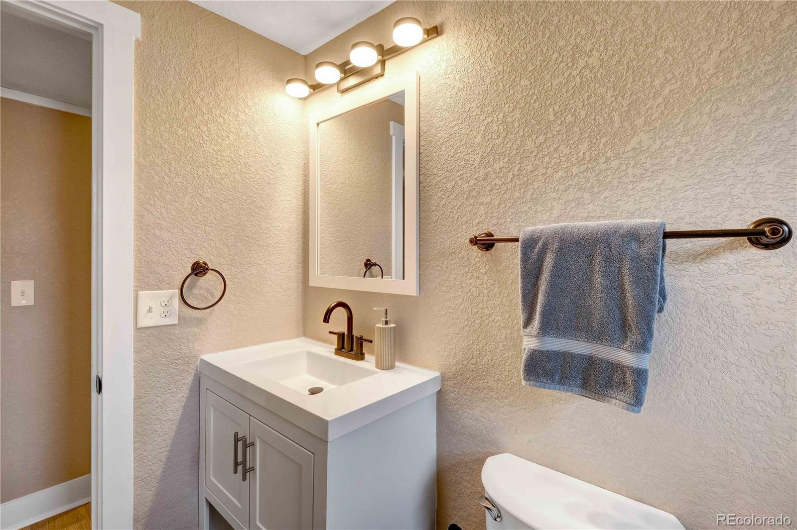 154 South Stuart Street Denver, CO 80219 - Photo 17 of 26 a bathroom with a sink toilet and mirror