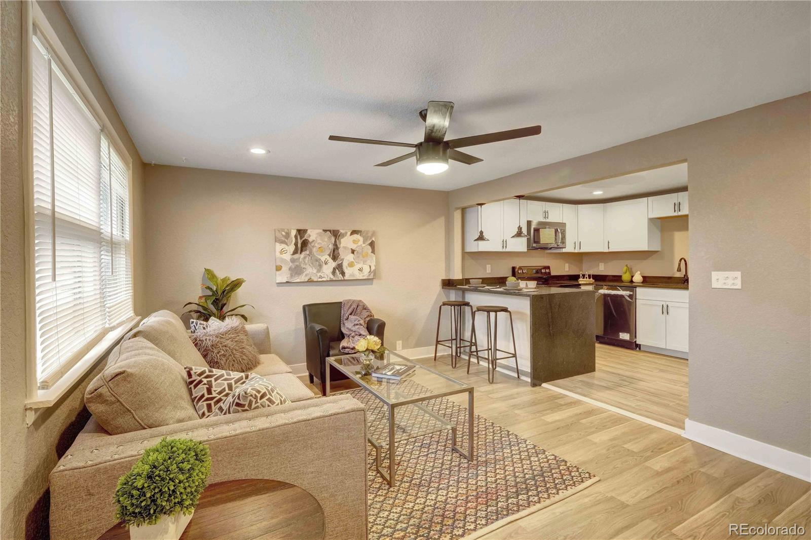 154 South Stuart Street Denver, CO 80219 - Photo 2 of 26 a living room with furniture kitchen view and a window