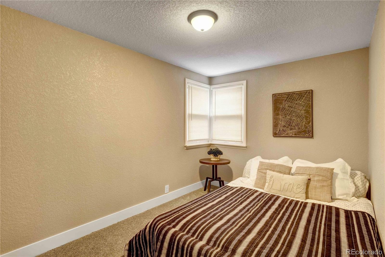 154 South Stuart Street Denver, CO 80219 - Photo 23 of 26 a bedroom with a bed and wooden floor