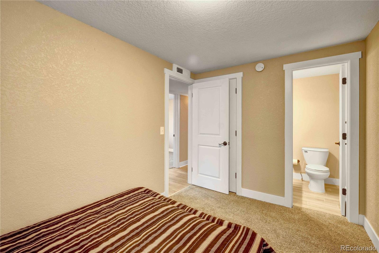154 South Stuart Street Denver, CO 80219 - Photo 24 of 26 a bedroom with a bed and a view of bathroom