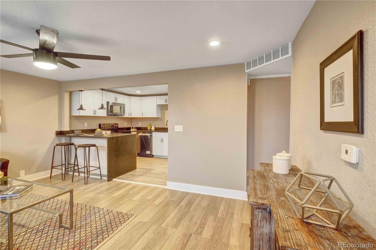 154 South Stuart Street Denver, CO 80219 - Photo 3 of 26 a kitchen with granite countertop a stove a sink and a refrigerator