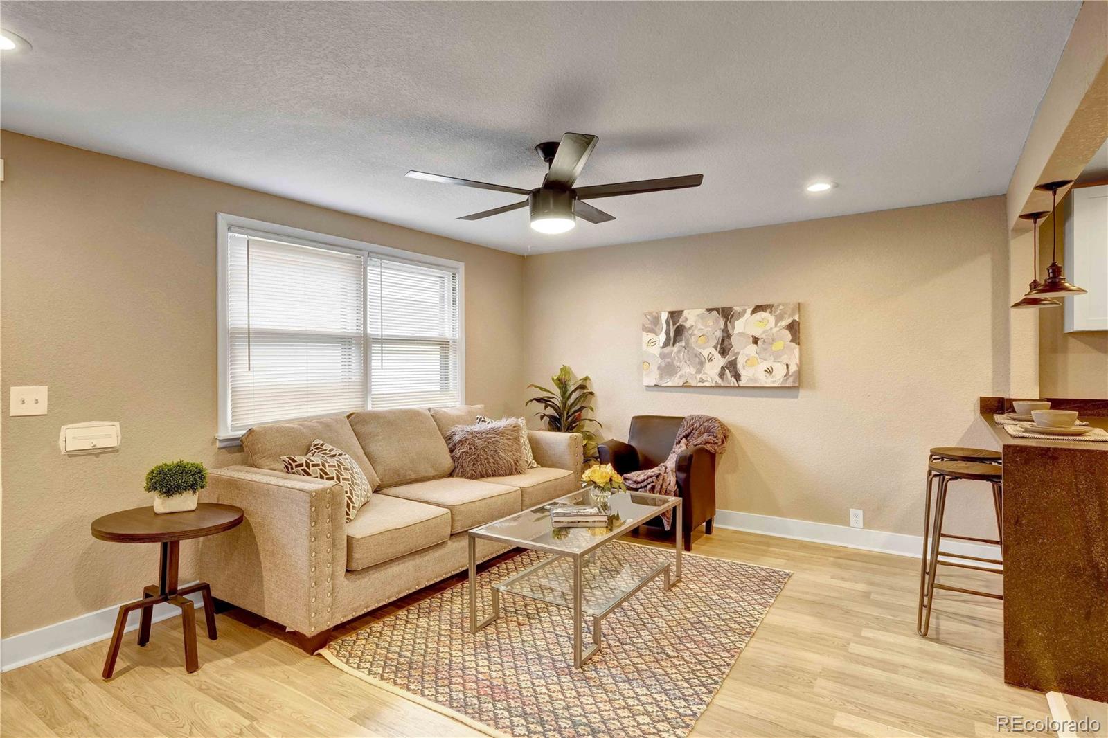 154 South Stuart Street Denver, CO 80219 - Photo 6 of 26 a living room with furniture a rug and a window