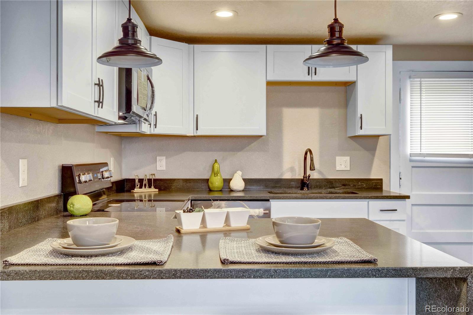 154 South Stuart Street Denver, CO 80219 - Photo 10 of 26 a kitchen with stainless steel appliances granite countertop a sink and a stove