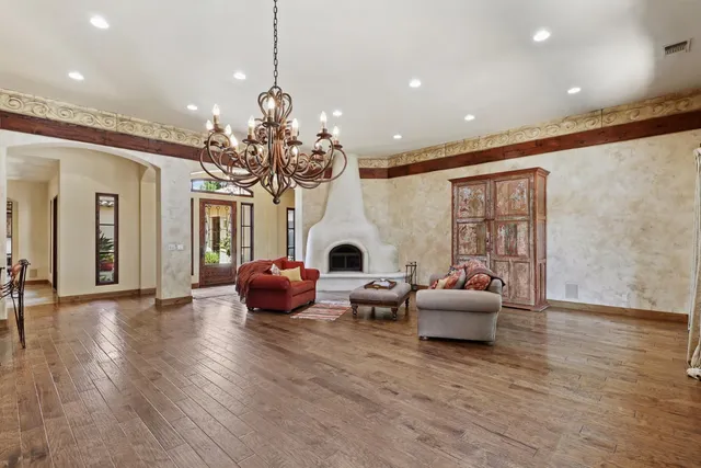a living room with furniture a flat screen tv and a floor to ceiling window