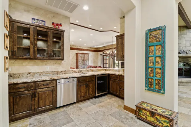 a kitchen with a stove a counter top space and living room view