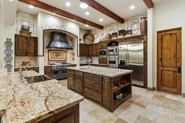 a view of a patio with table and chairs potted plants and floor to ceiling window and potted plants