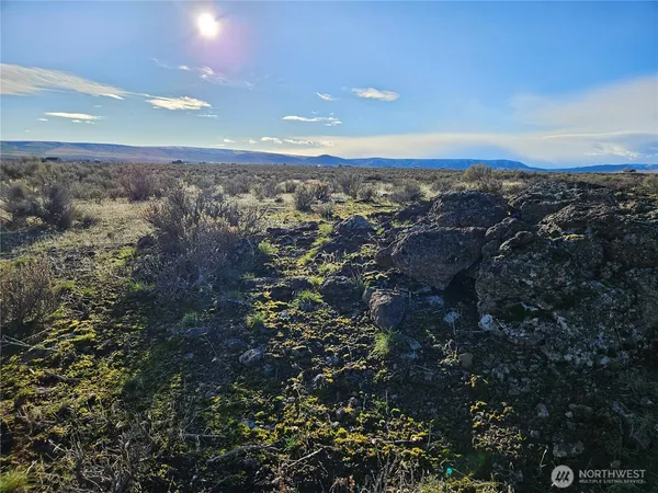 an aerial view of house with yard and mountain view in back