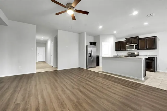 a view of kitchen with microwave refrigerator and cabinets