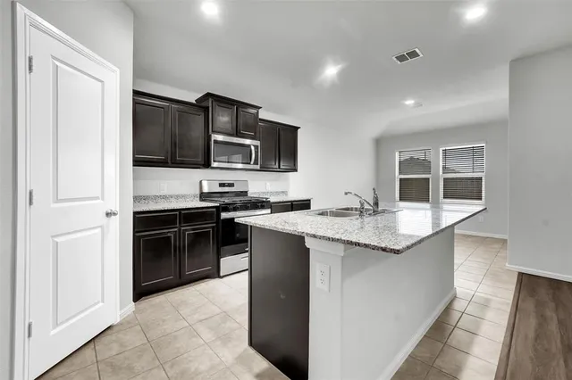 a kitchen with stainless steel appliances granite countertop a stove and a sink