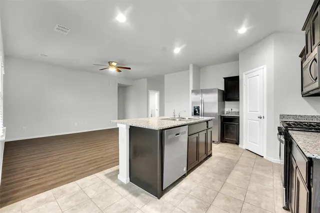 a kitchen with granite countertop a sink and a stove top oven