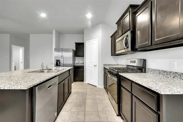 a kitchen with granite countertop stainless steel appliances and wooden cabinets