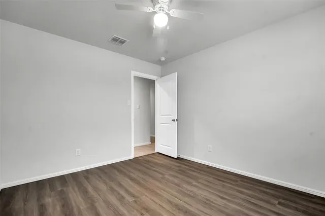 a view of a room with wooden floor and a ceiling fan