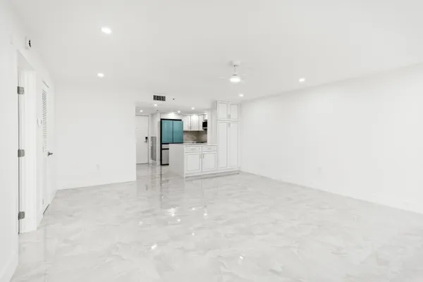 an empty room with a kitchen space and window