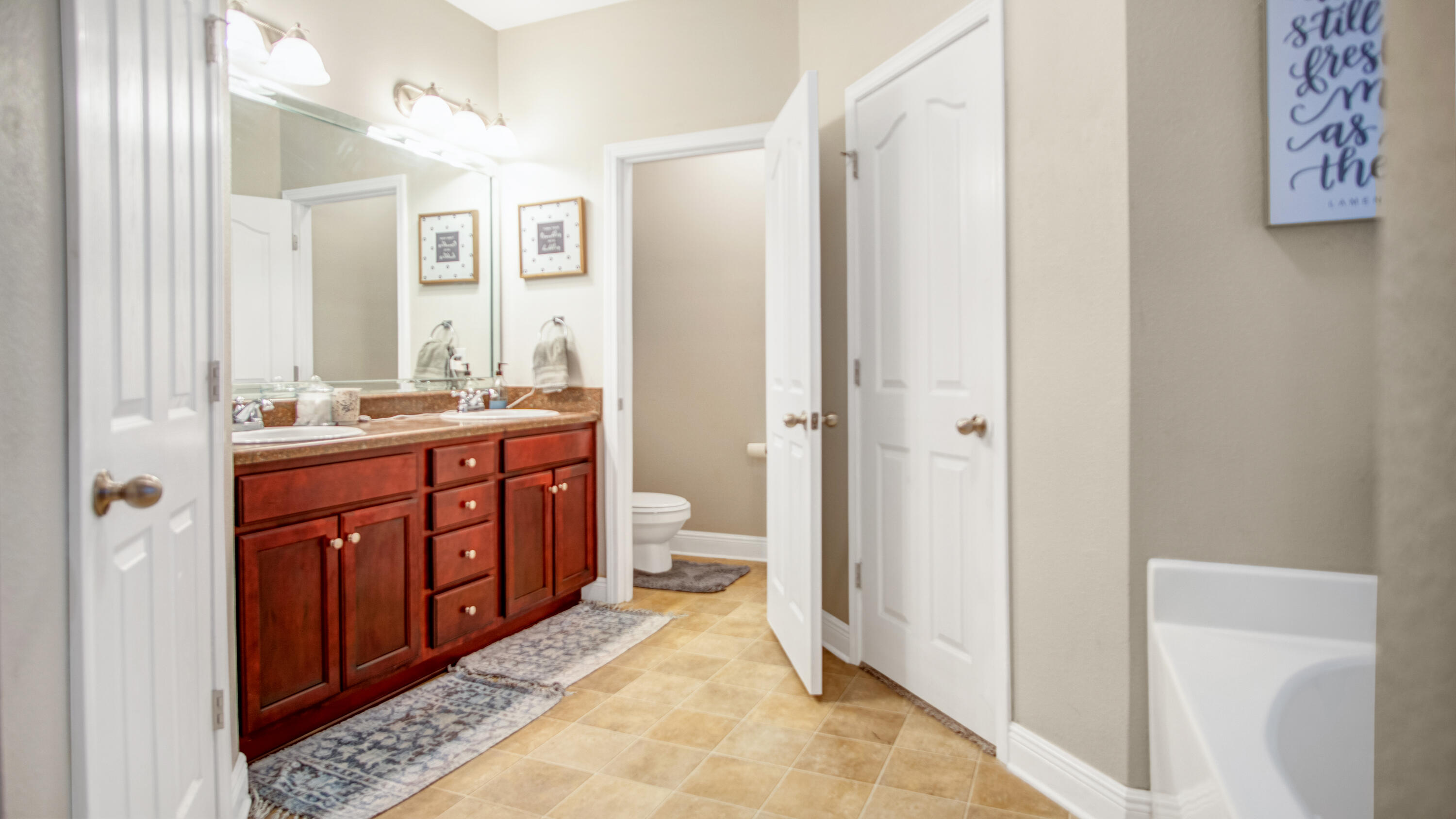 744 Lime Lane Crestview, FL 32536 - Photo 17 of 33 a spacious bathroom with a double vanity sink a toilet and a shower