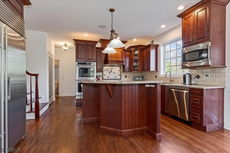 1 Brodziak Road Denville, NJ 07834 - Photo 10 of 42 a kitchen with stainless steel appliances granite countertop a refrigerator a sink dishwasher a oven with wooden cabinets and wooden floor