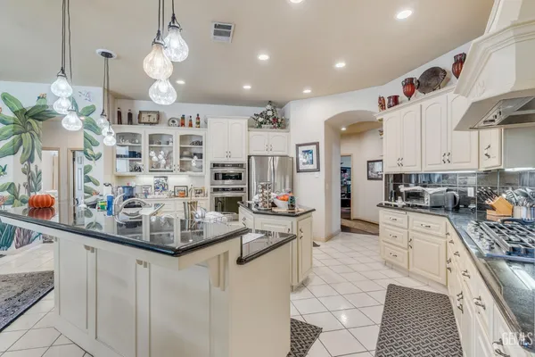 a living room with furniture a chandelier and a dining table