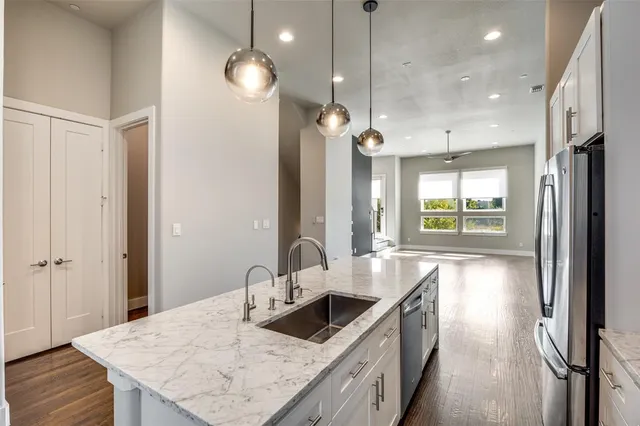 a bathroom with a granite countertop bathtub shower sink vanity and toilet
