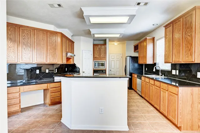 a large kitchen with stainless steel appliances granite countertop a stove a sink and a microwave