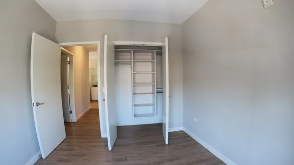 an empty room with wooden floor and closet
