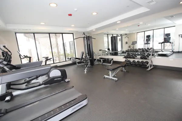 a room with gym equipment and large windows