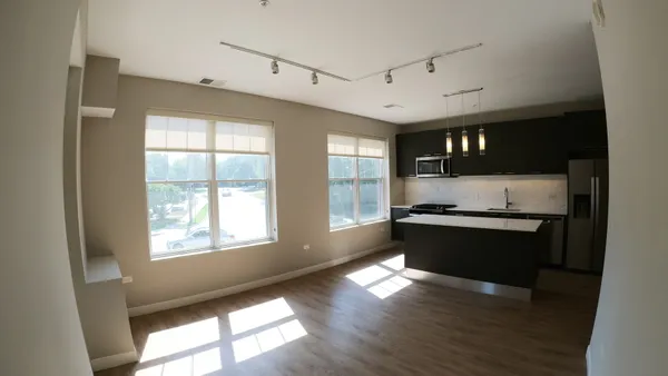 a large white kitchen with granite countertop a stove a sink and a window