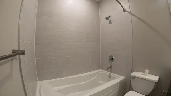 a white bath tub sitting next to a toilet