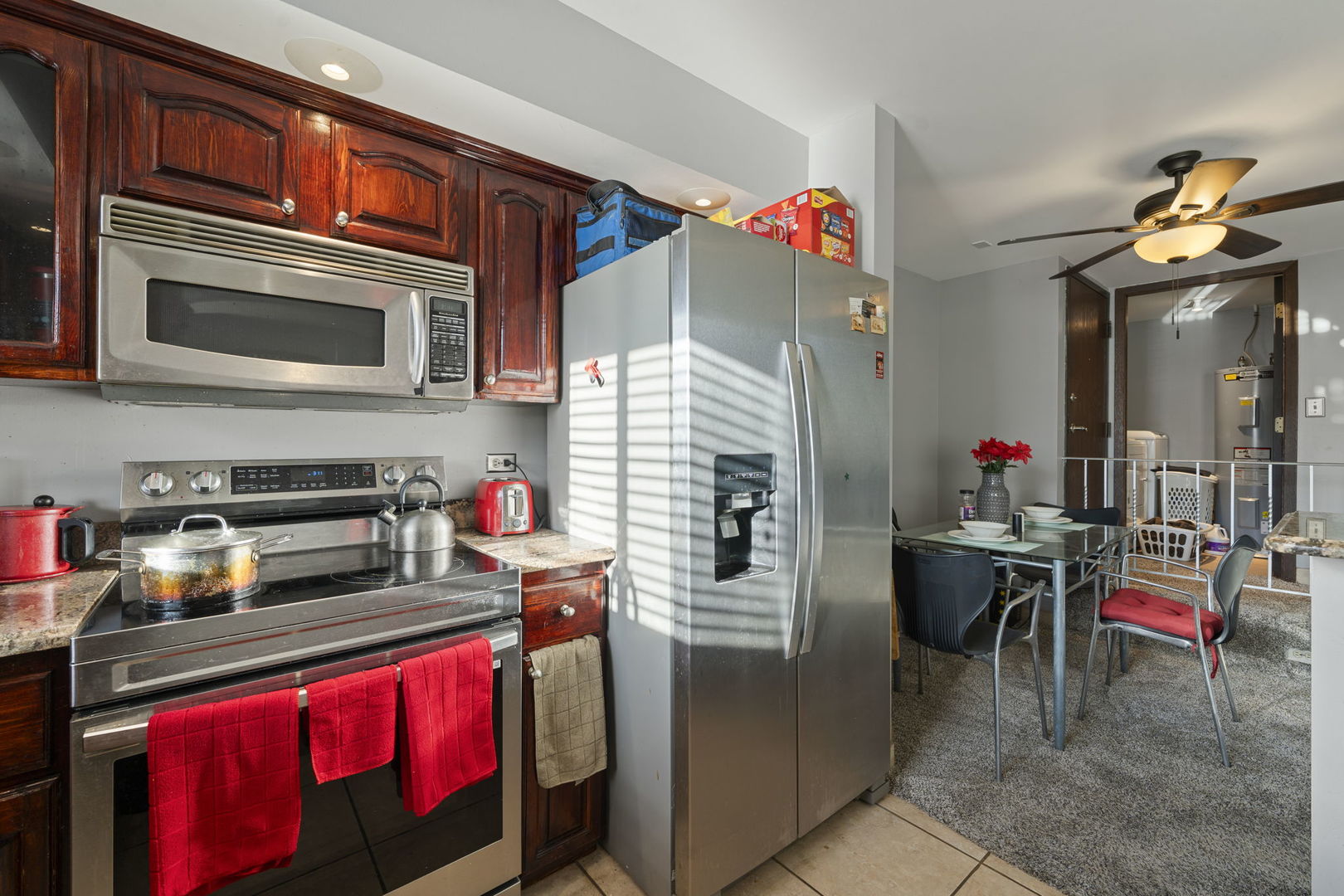 756 Rodenburg Road, Unit 1C Roselle, IL 60172 - Photo 5 of 28 a kitchen with stainless steel appliances a stove a microwave and a dining table