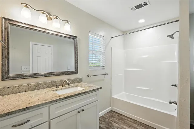 a bathroom with a granite countertop sink mirror and vanity