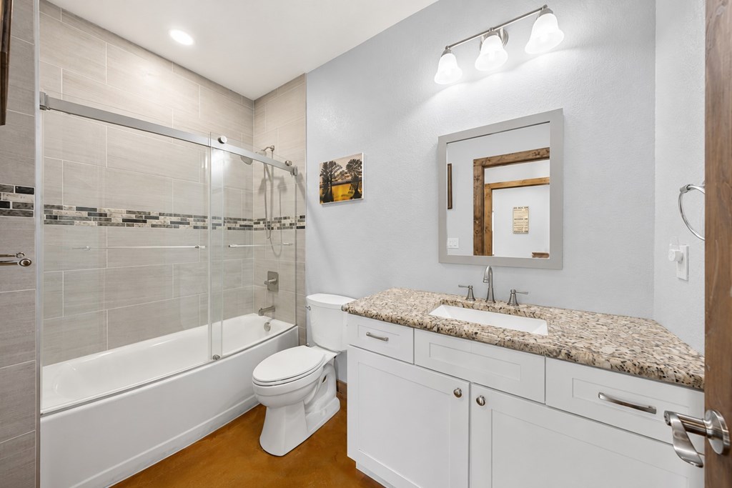 161 Balsly Road East Center Point, TX 78010 - Photo 21 of 28 a bathroom with a granite countertop sink toilet and shower
