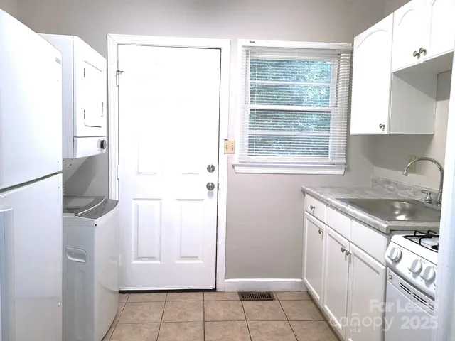 a kitchen with a sink a refrigerator and window