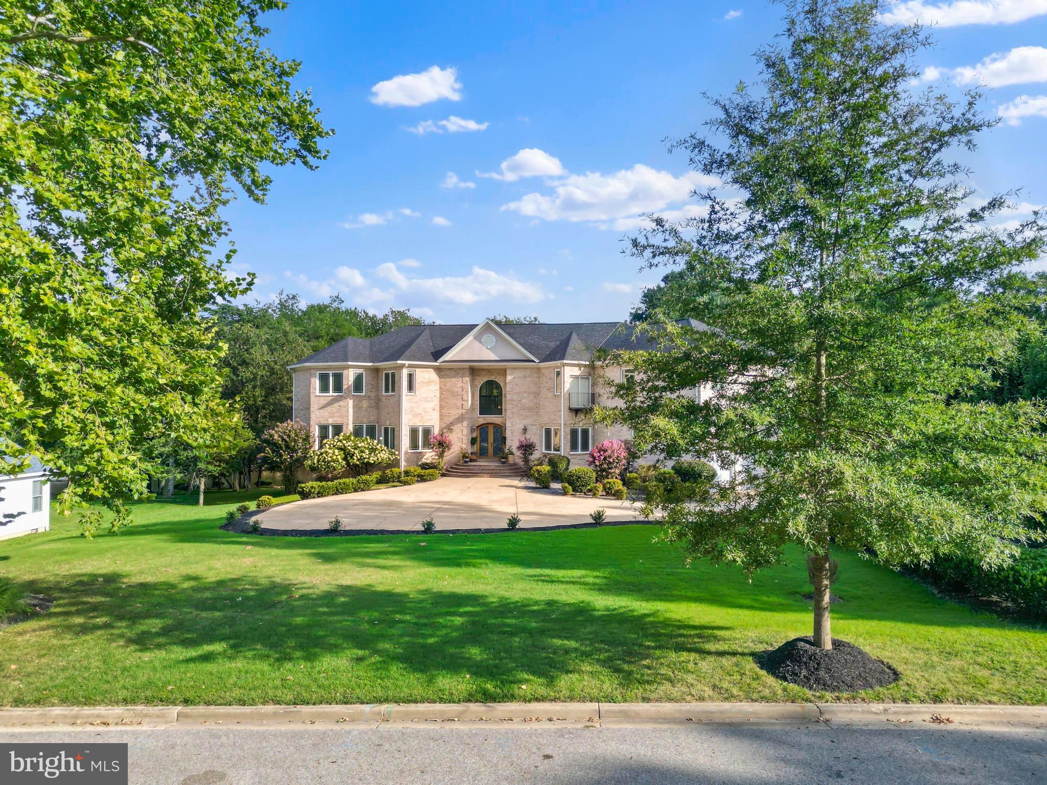 a front view of a house with garden and sitting area