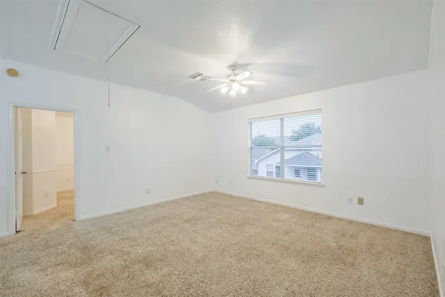 a view of an empty room with a chandelier fan
