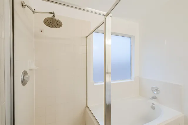 a bathroom with a tub sink shower and mirror